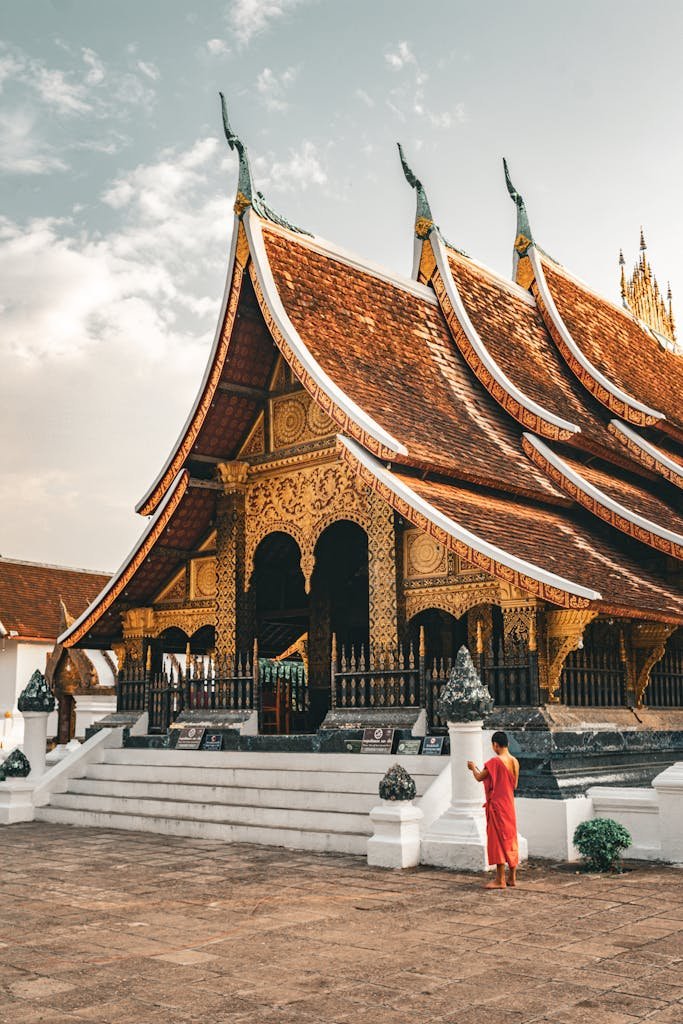 Scenic view of Wat Xieng Thong Temple with ornate roof and intricate details in Luang Prabang, Laos.
