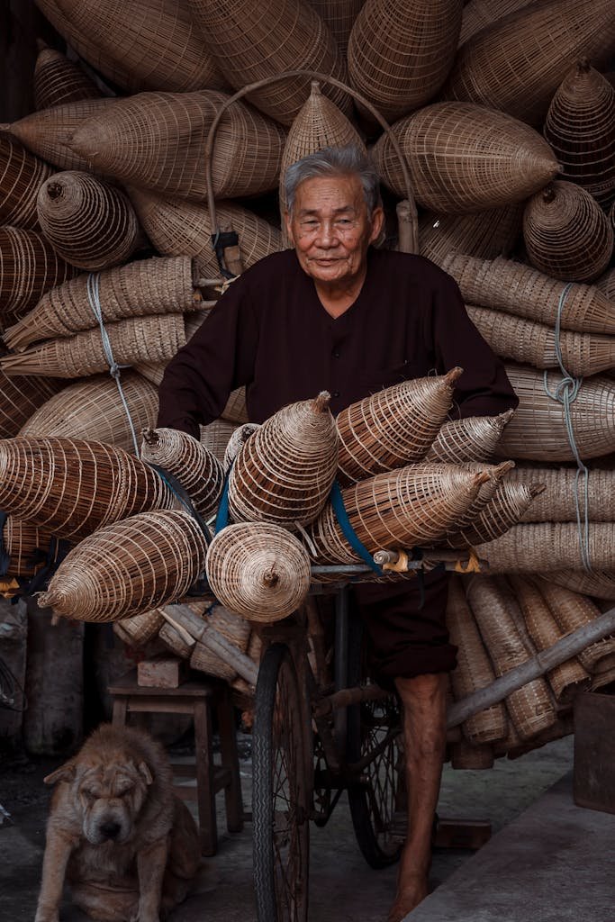 Senior man standing with handmade wicker baskets on a bicycle.